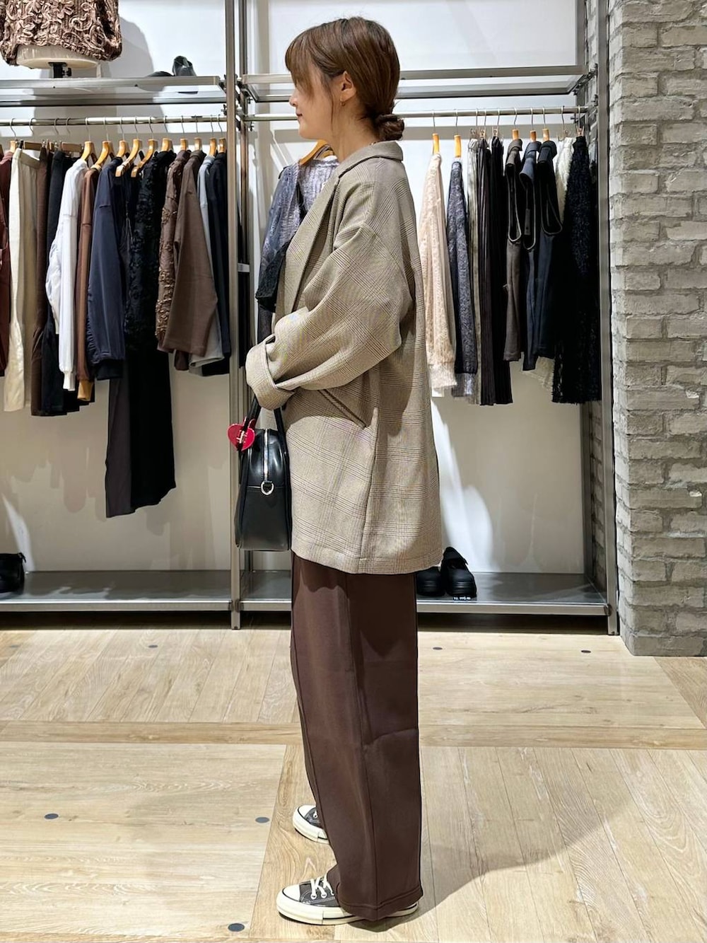 ホワイト系のTシャツ/カットソー、ブラウン系のスニーカー、ブラウン系のスウェットパンツを着用したレディースの秋コーディネートの3枚目の写真