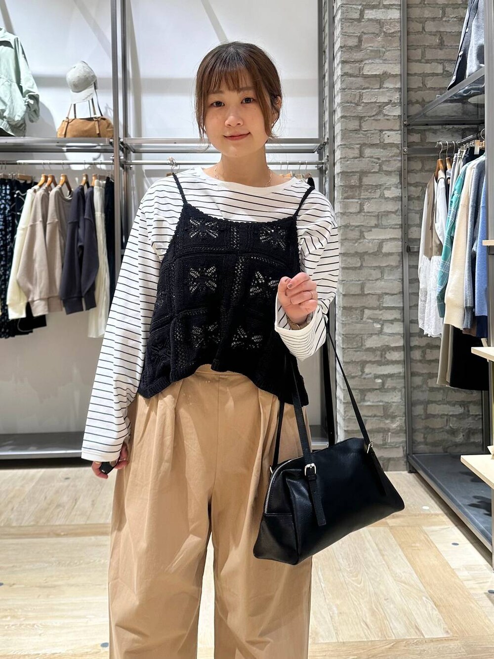 ブラック系のボストンバッグ、ホワイト系のTシャツ/カットソー、ベージュ系のその他パンツを着用したレディースの春コーディネートの4枚目の写真