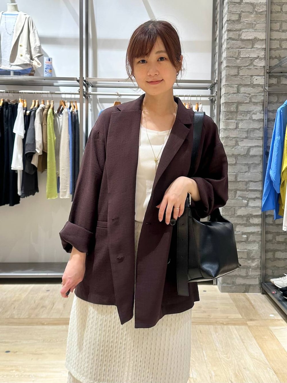 ブラック系のショルダーバッグ、ブラック系のパンプス、ブラウン系のテーラードジャケットを着用したレディースの春コーディネートの4枚目の写真