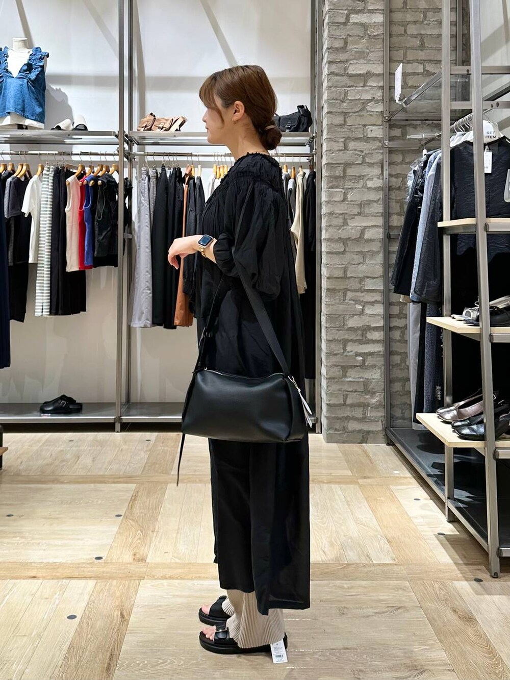 ブラック系のショルダーバッグ、ブラック系のワンピース、ブラック系のサンダルを着用したレディースの春コーディネートの2枚目の写真