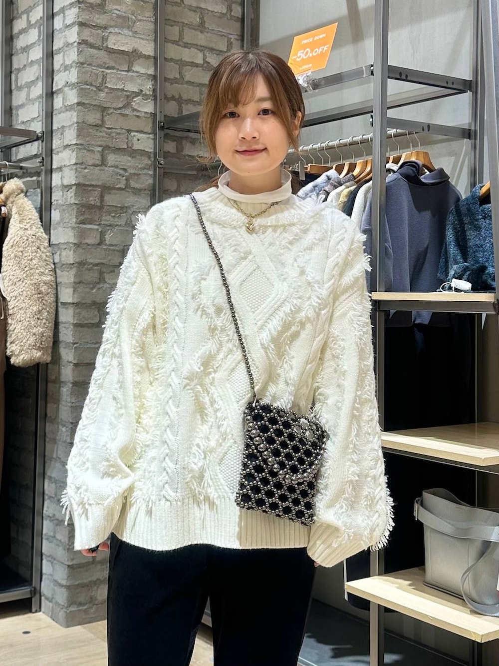 ホワイト系のTシャツ/カットソー、ブラック系のショルダーバッグ、ブラック系のその他パンツを着用したレディースの冬コーディネートの4枚目の写真