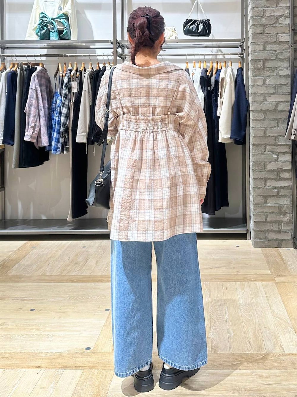 ブルー系のデニムパンツ、ブラック系のその他シューズ、ブラック系のトートバッグを着用したレディースの春コーディネートの3枚目の写真