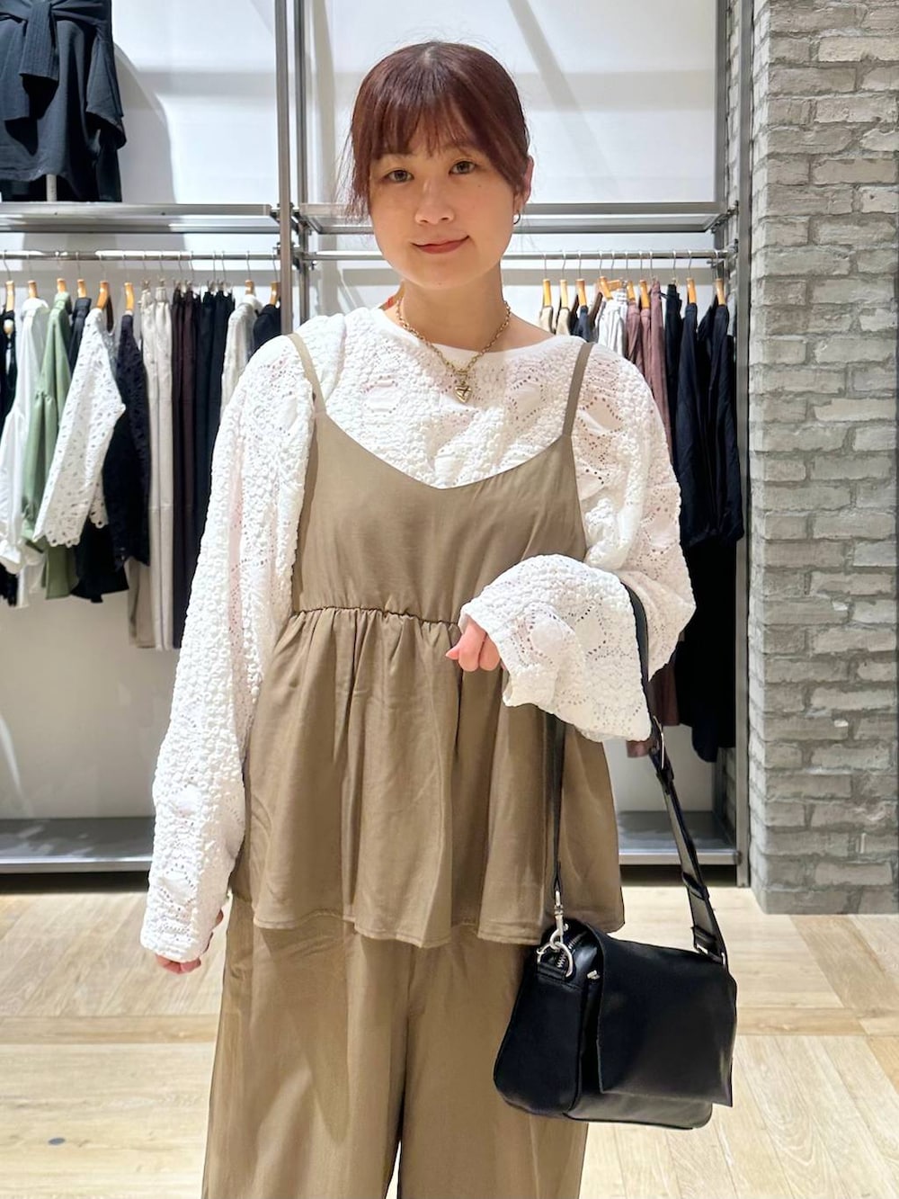 ブラック系のショルダーバッグ、ホワイト系のTシャツ/カットソー、ブラック系のパンプスを着用したレディースの春コーディネートの4枚目の写真