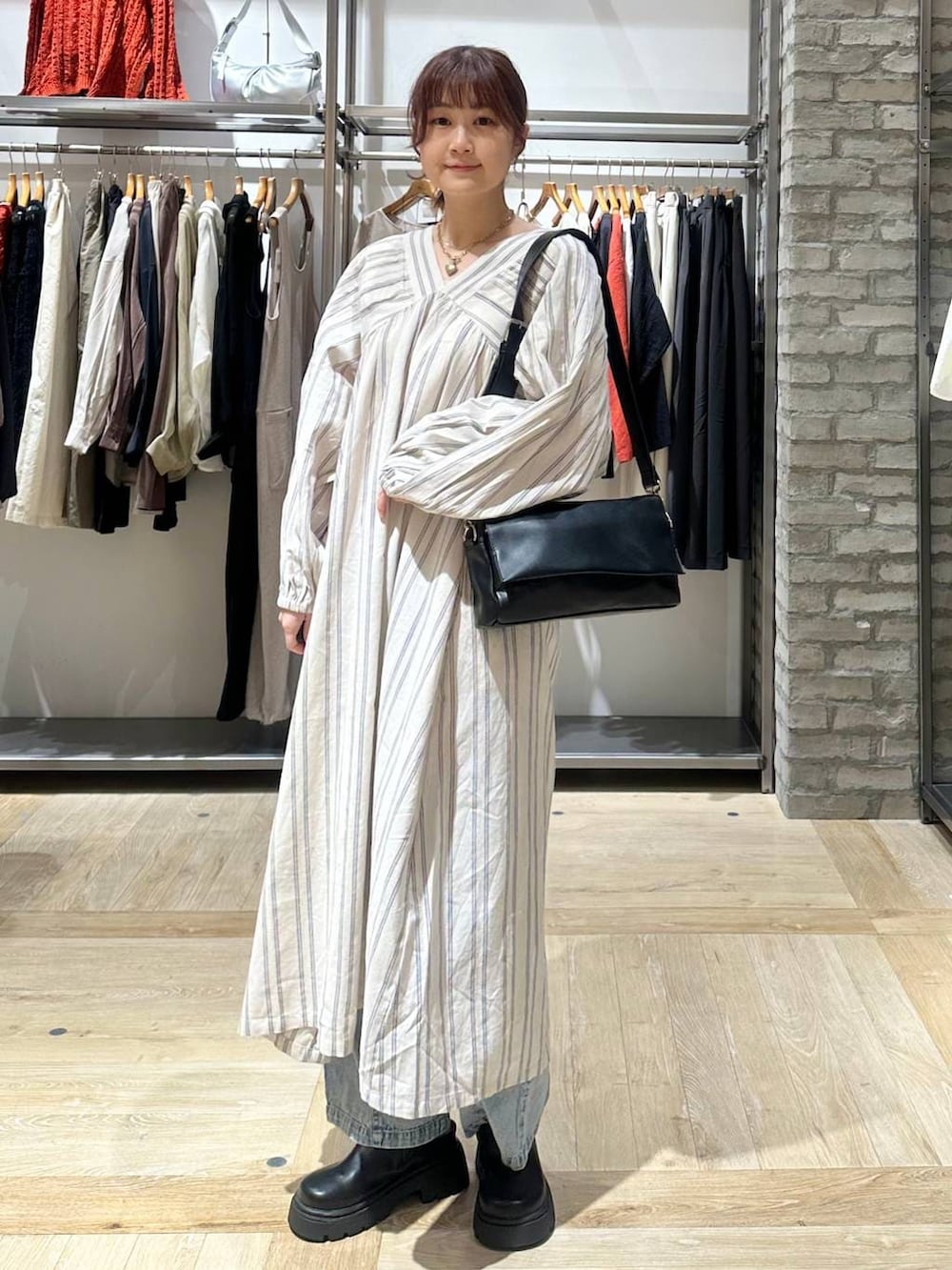 ブラック系のショルダーバッグ、ホワイト系のワンピース、ブラック系のその他シューズを着用したレディースの春コーディネートの2枚目の写真