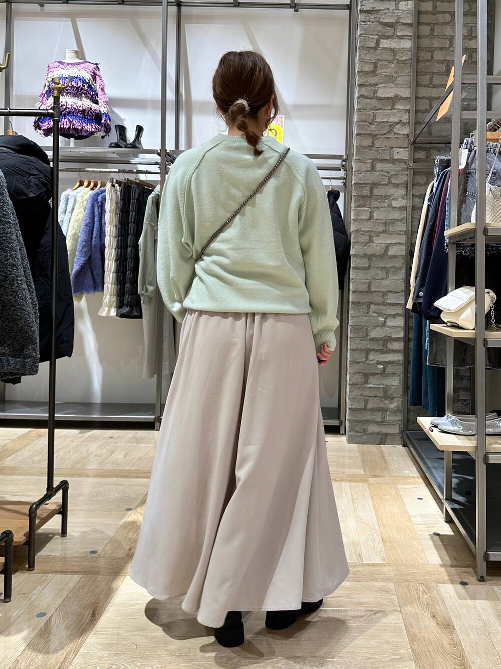 グリーン系のニット/セーター、ブラック系のブーツ、ベージュ系のその他パンツを着用したレディースの秋コーディネートの4枚目の写真