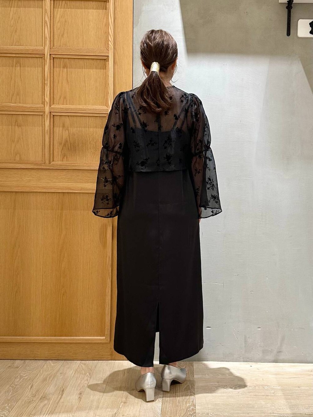 シルバー系のパンプス、ブラック系のショルダーバッグ、ブラック系のワンピースを着用したレディースの秋コーディネートの3枚目の写真