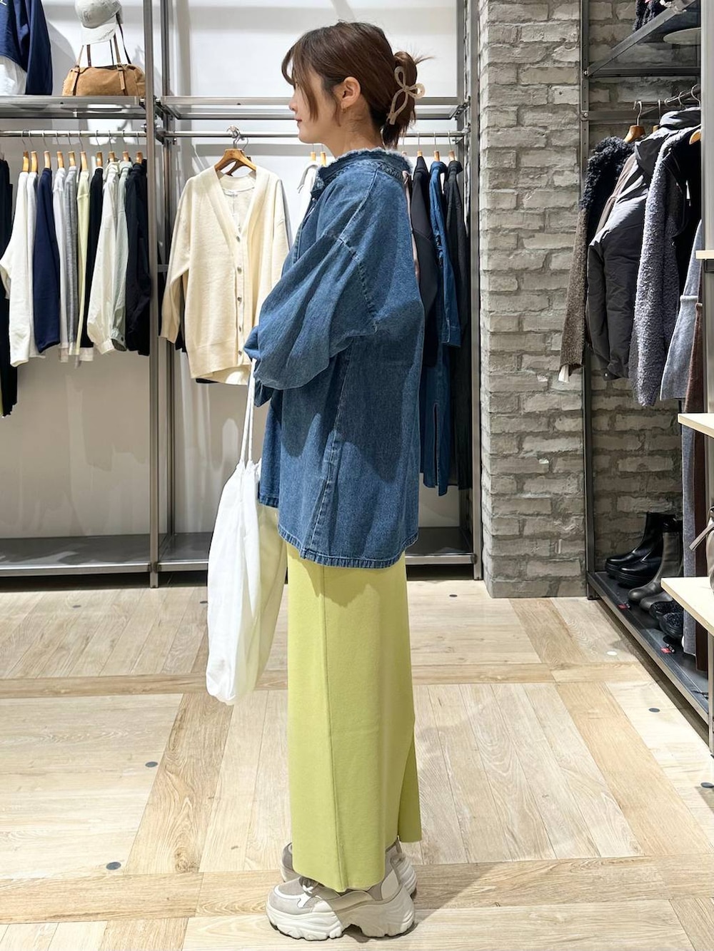 グリーン系のスカート、ブラック系のTシャツ/カットソー、ホワイト系のトートバッグを着用したレディースの冬コーディネートの3枚目の写真