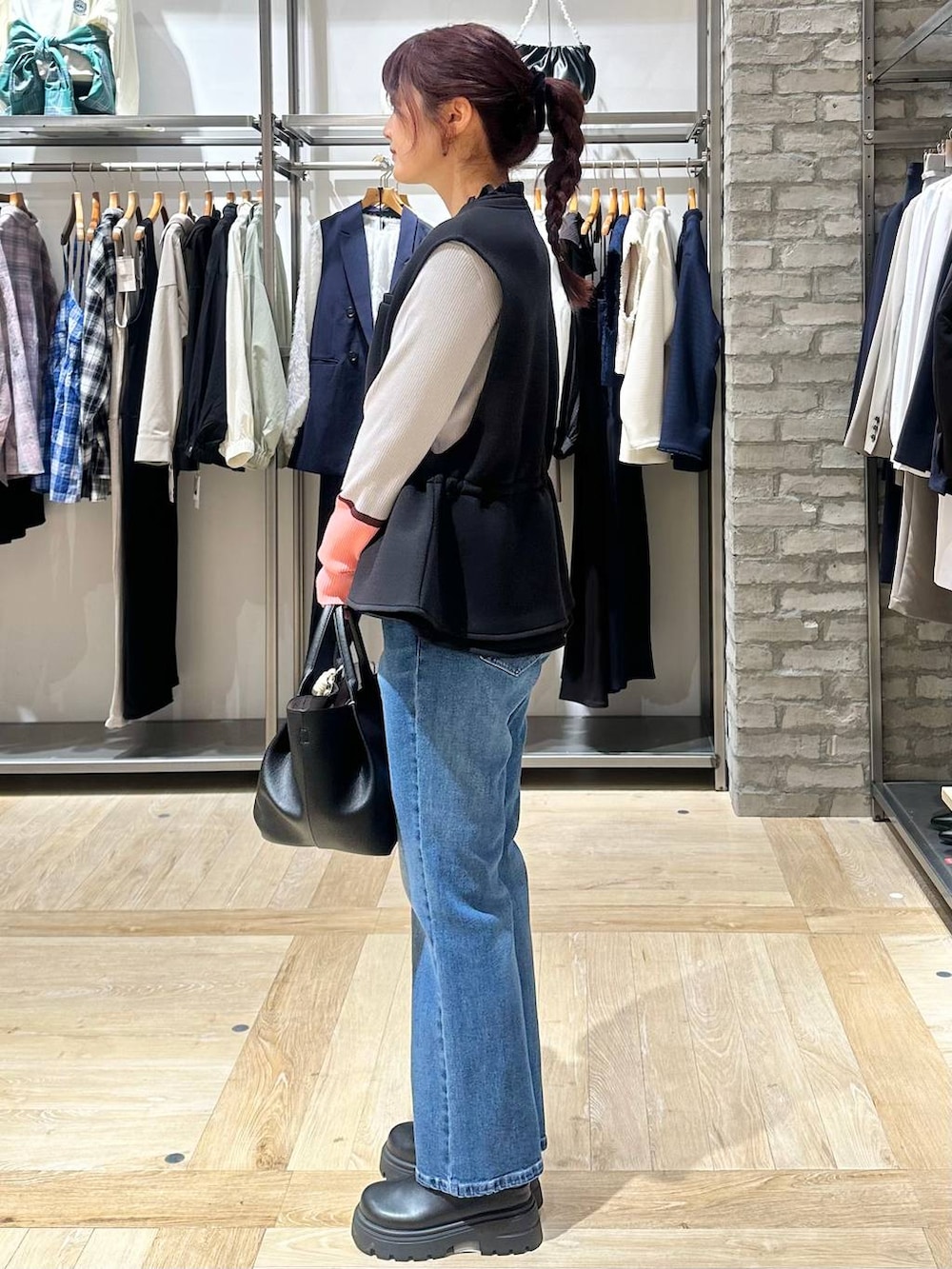 ブラック系のその他シューズ、ブラック系のトートバッグ、ブルー系のデニムパンツを着用したレディースの春コーディネートの2枚目の写真