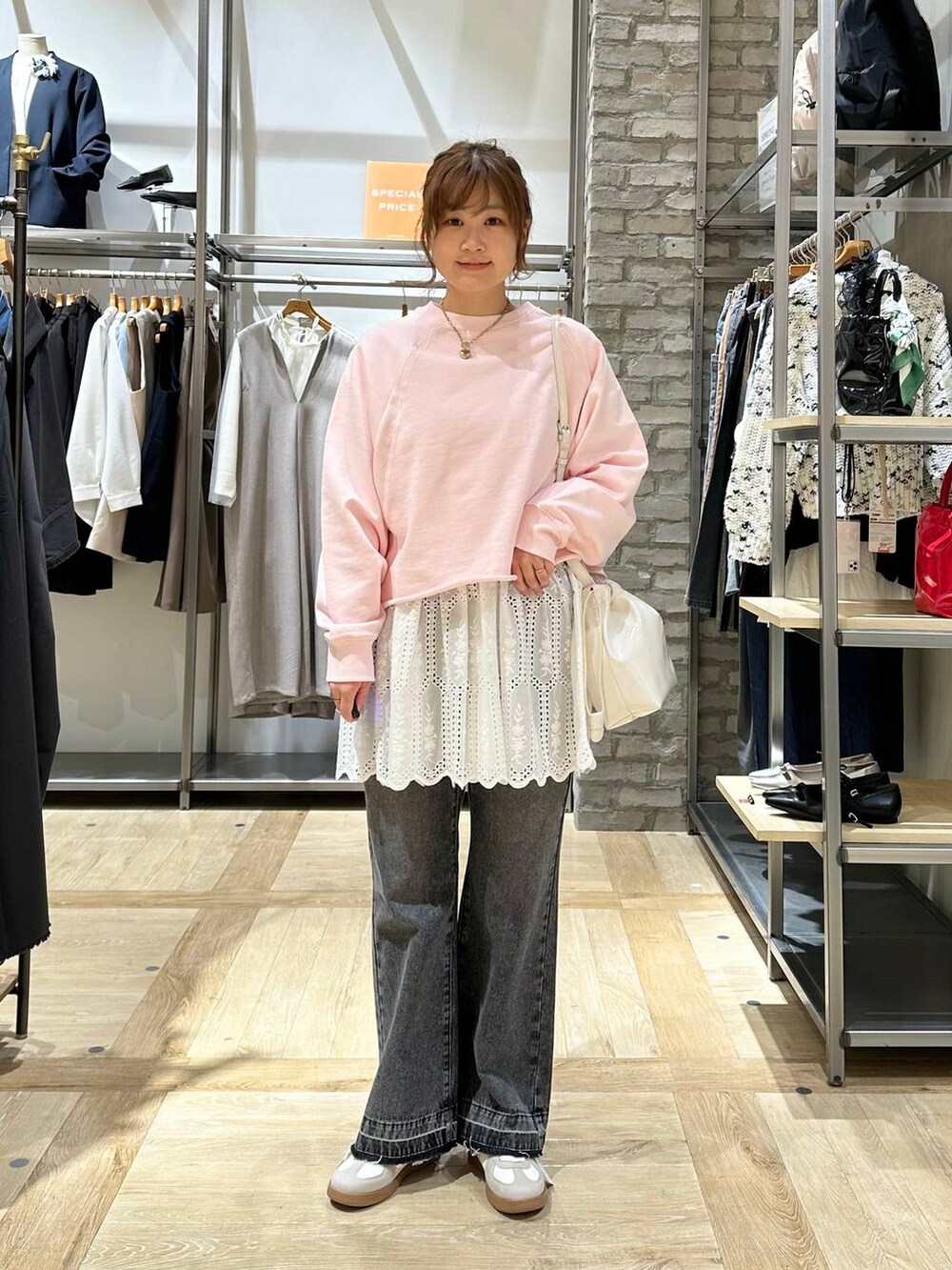 ホワイト系のTシャツ/カットソー、ブラック系のデニムパンツ、ホワイト系のスニーカーを着用したレディースの春コーディネートの2枚目の写真