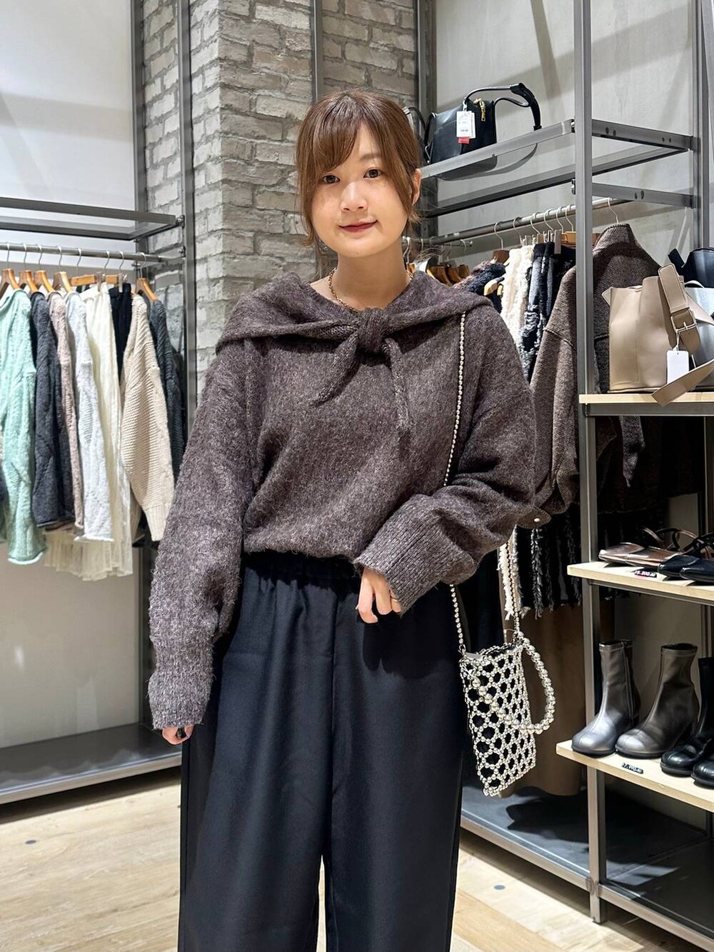 シルバー系のショルダーバッグ、ブラック系のその他パンツ、ブラック系のブーツを着用したレディースの秋コーディネートの4枚目の写真