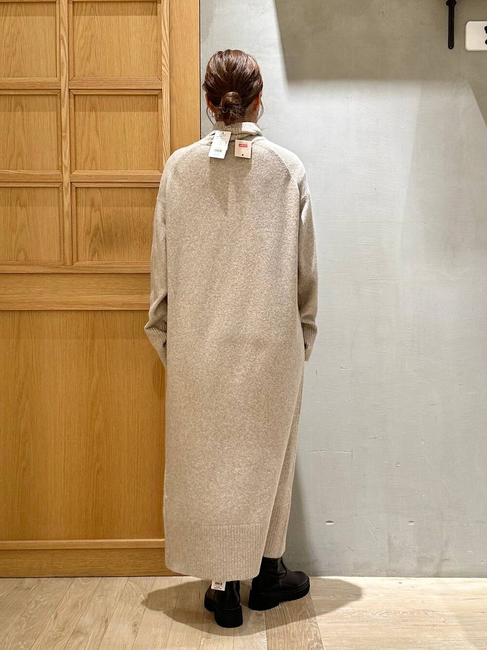 ブラック系のショルダーバッグ、ブラック系のブーツ、ベージュ系のワンピースを着用したレディースの冬コーディネートの5枚目の写真