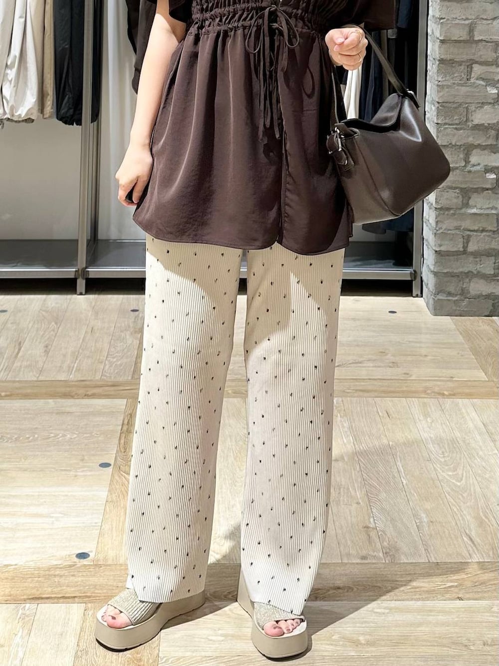 ベージュ系のその他パンツ、ブラウン系のシャツ/ブラウス、ブラウン系のショルダーバッグを着用したレディースの夏コーディネートの5枚目の写真