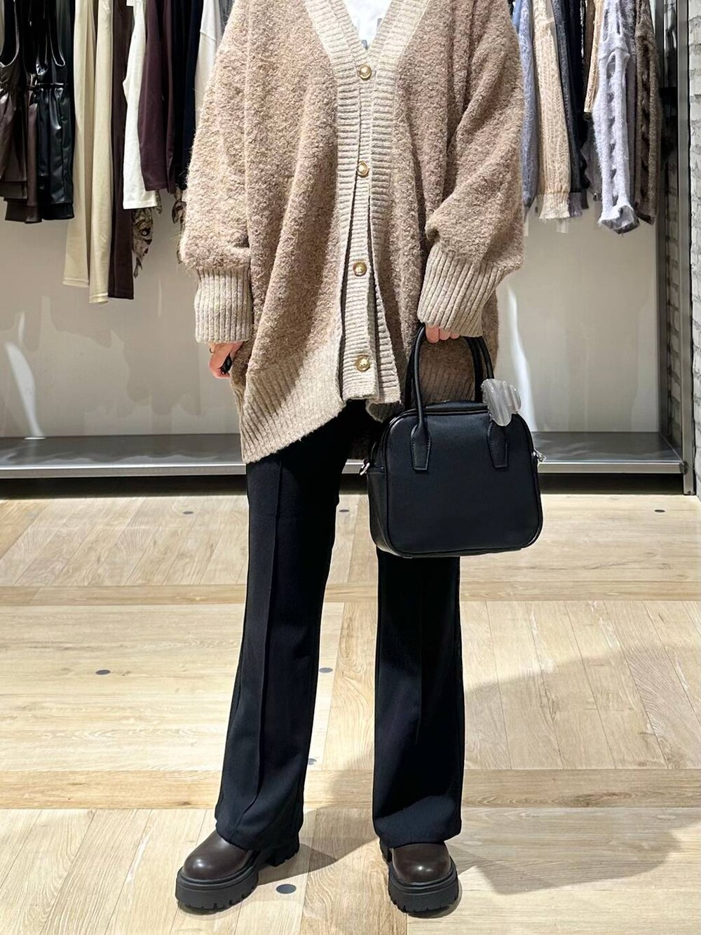 ブラック系のその他パンツ、ブラック系のボストンバッグ、ブラウン系のカーディガン/ボレロを着用したレディースの秋コーディネートの6枚目の写真