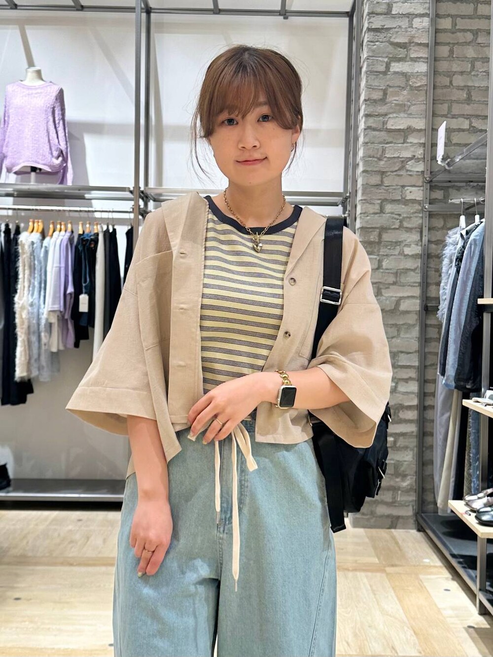 イエロー系のタンクトップ、ベージュ系のシャツ/ブラウス、ブラック系のショルダーバッグを着用したレディースの春コーディネートの5枚目の写真