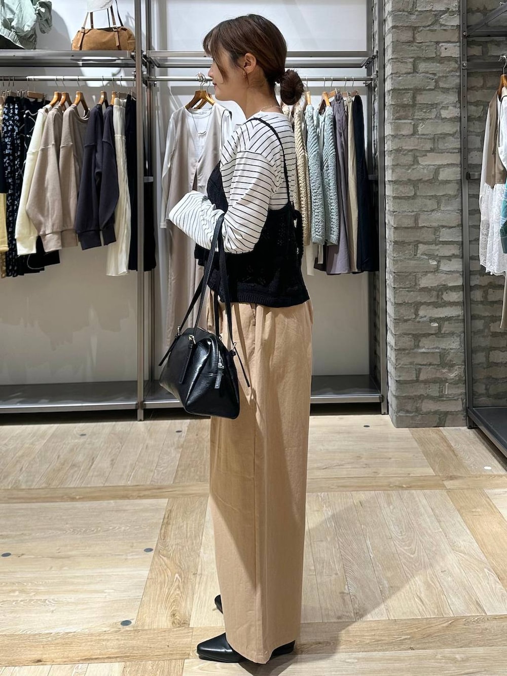 ブラック系のボストンバッグ、ホワイト系のTシャツ/カットソー、ベージュ系のその他パンツを着用したレディースの春コーディネートの2枚目の写真