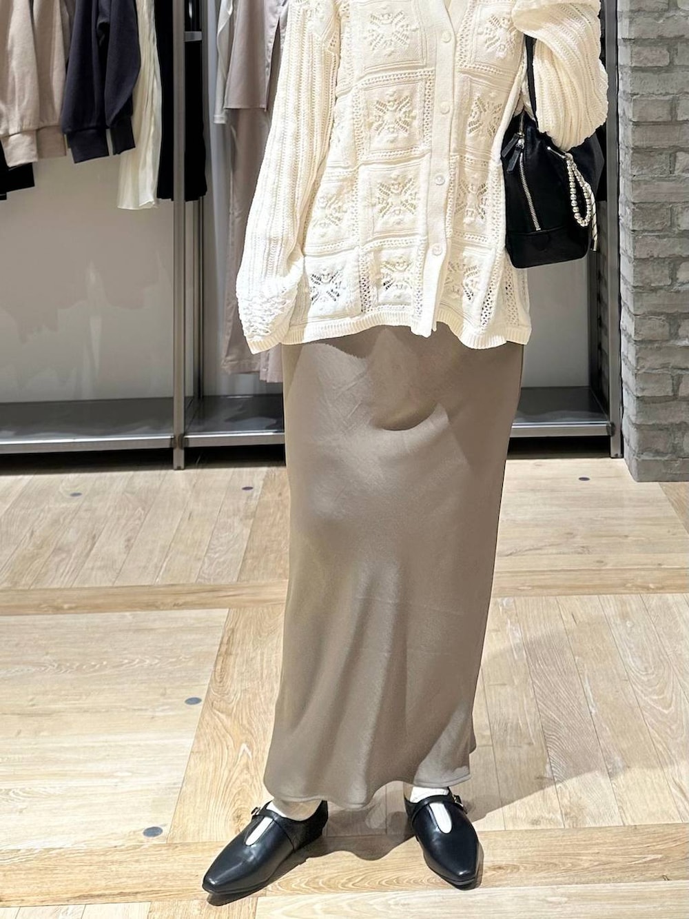 グリーン系のスカート、ホワイト系のTシャツ/カットソー、ブラック系のボストンバッグを着用したレディースの春コーディネートの5枚目の写真