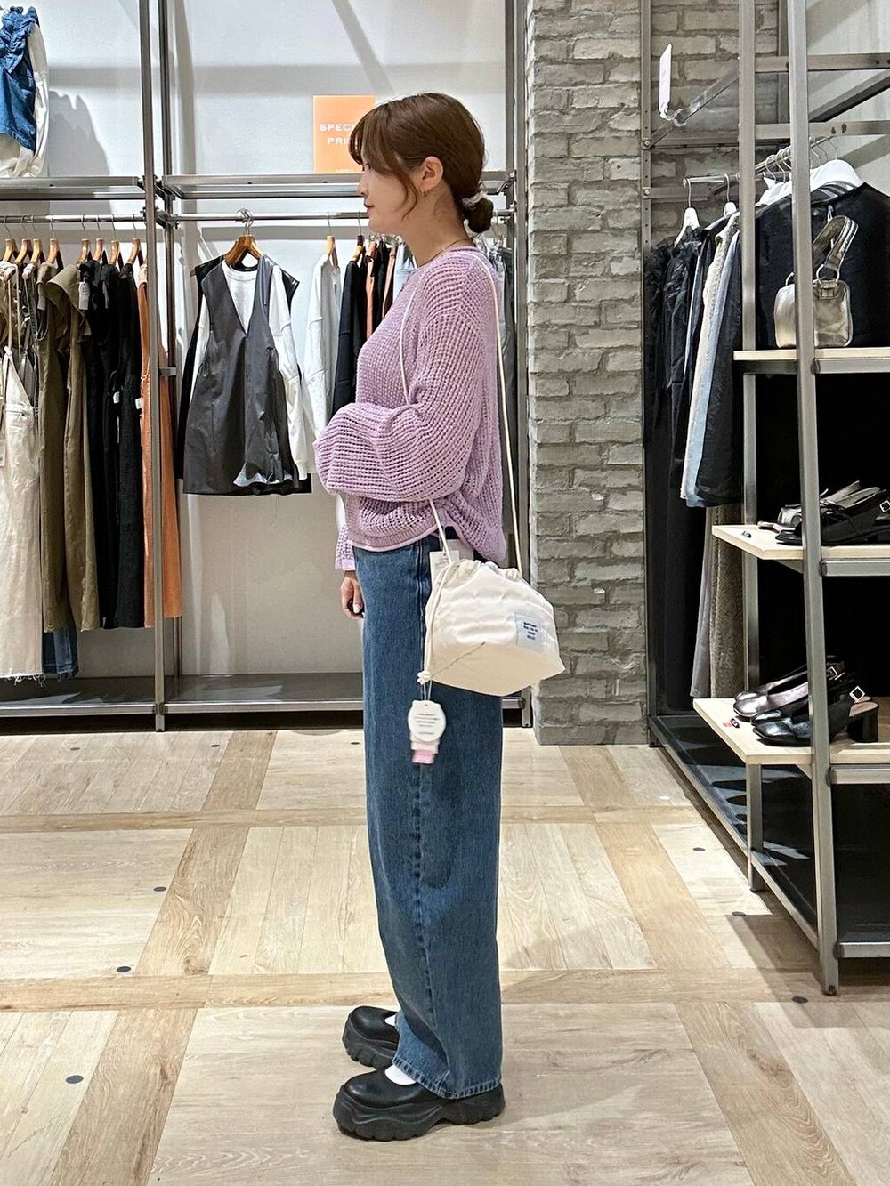 ブラック系のスニーカー、ブルー系のデニムパンツ、ブラック系のショルダーバッグを着用したレディースの春コーディネートの2枚目の写真