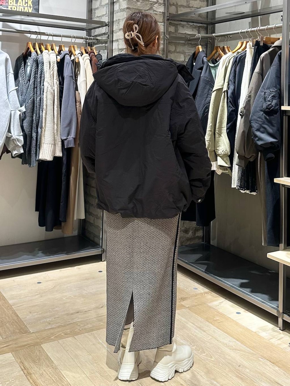 ホワイト系のブーツ、ブラック系のスカート、ブラック系のその他アウターを着用したレディースの冬コーディネートの3枚目の写真