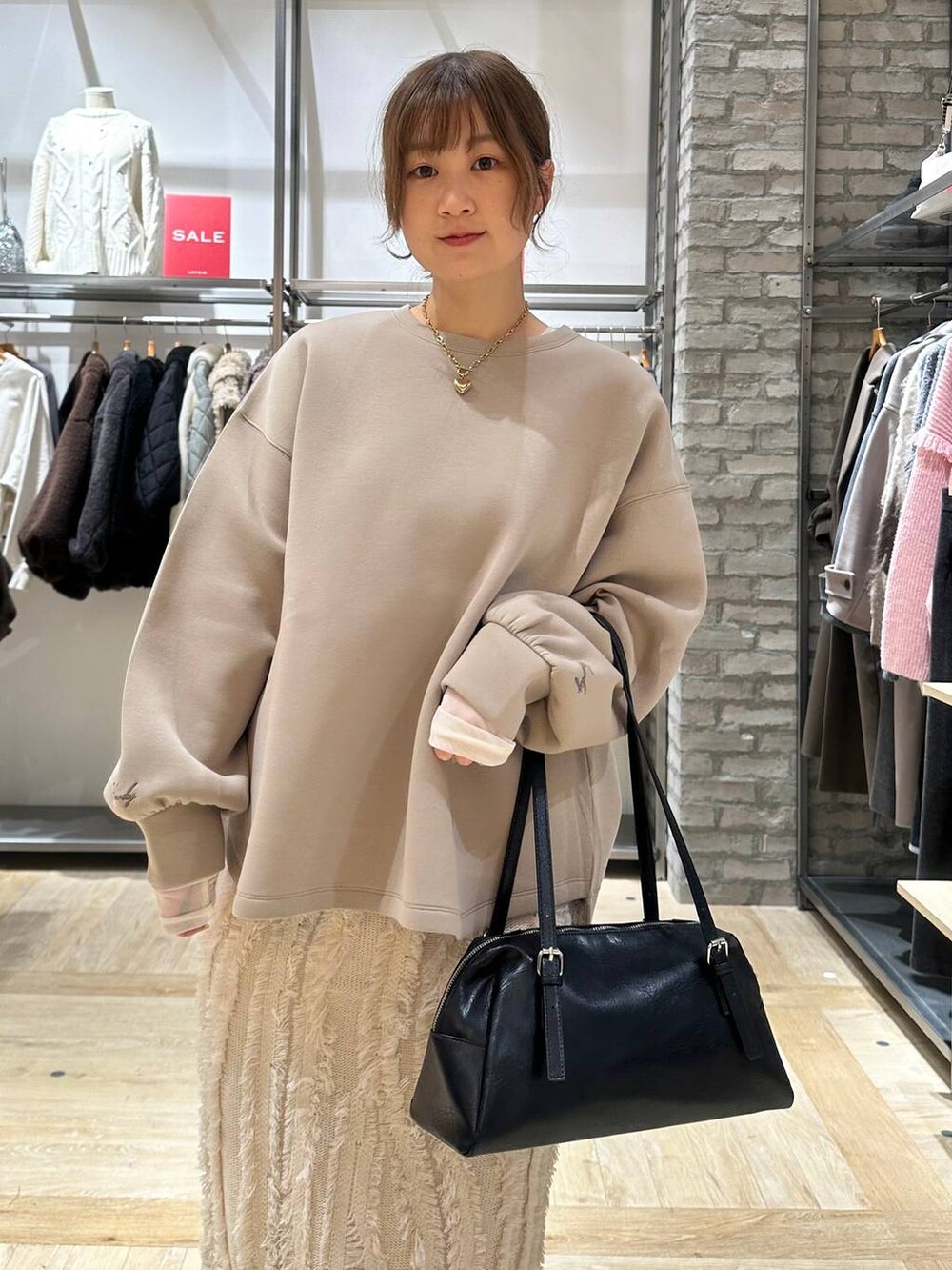 ブラック系のサンダル、ブラック系のボストンバッグ、ホワイト系のスカートを着用したレディースの冬コーディネートの4枚目の写真