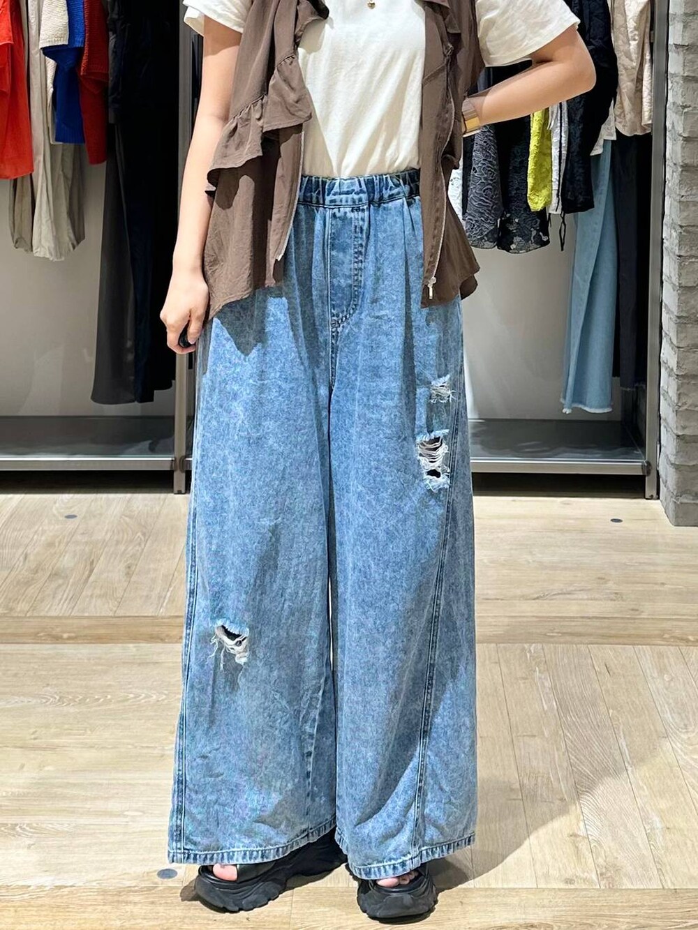 ブラウン系のベスト、ブルー系のデニムパンツ、ホワイト系のTシャツ/カットソーを着用したレディースの夏コーディネートの4枚目の写真