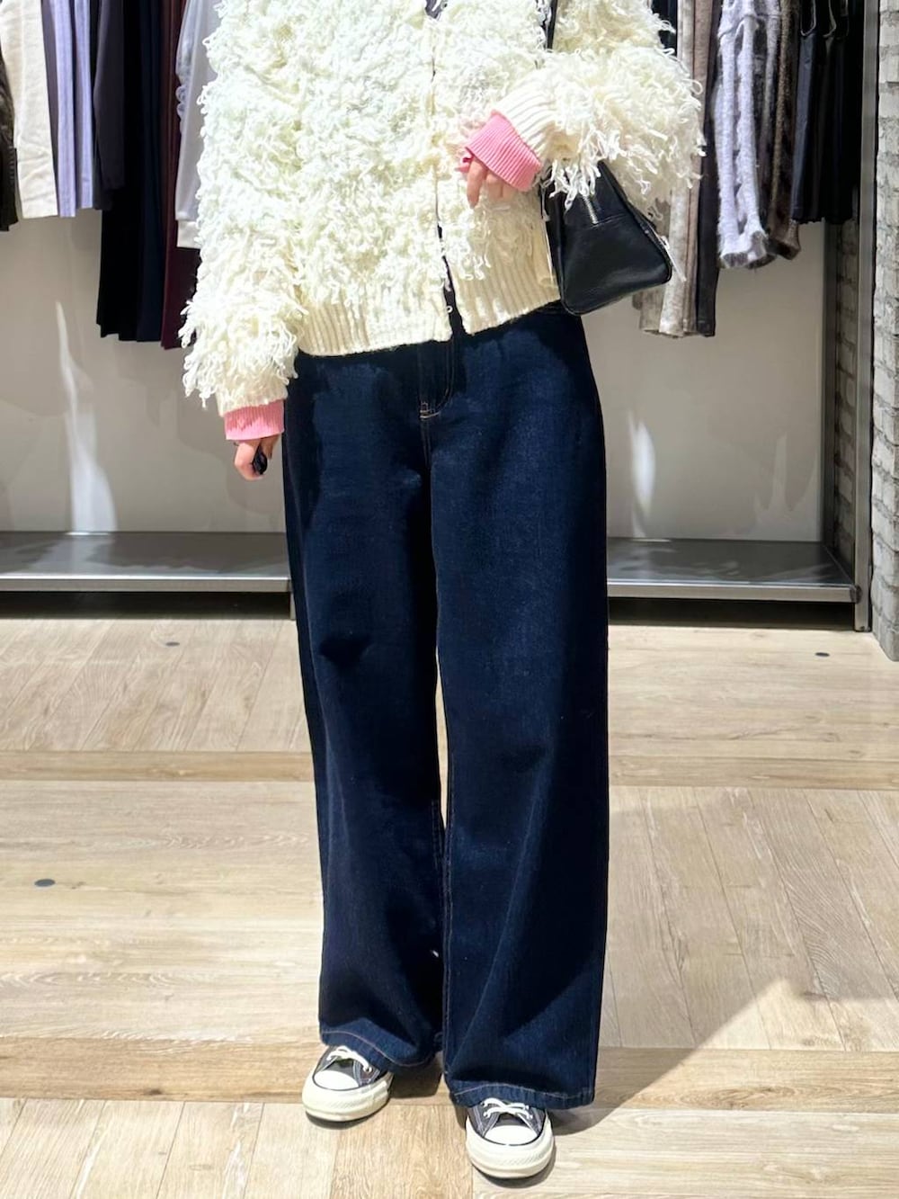 ブルー系のデニムパンツ、グレー系のニット/セーター、ブラック系のボストンバッグを着用したレディースの秋コーディネートの6枚目の写真