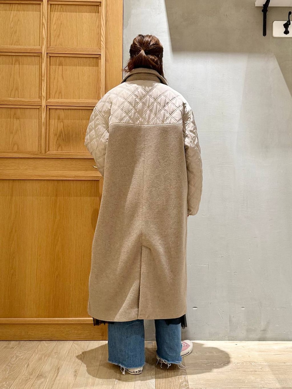 ブラック系のトートバッグ、ブルー系のデニムパンツ、ホワイト系のニット/セーターを着用したレディースの冬コーディネートの4枚目の写真