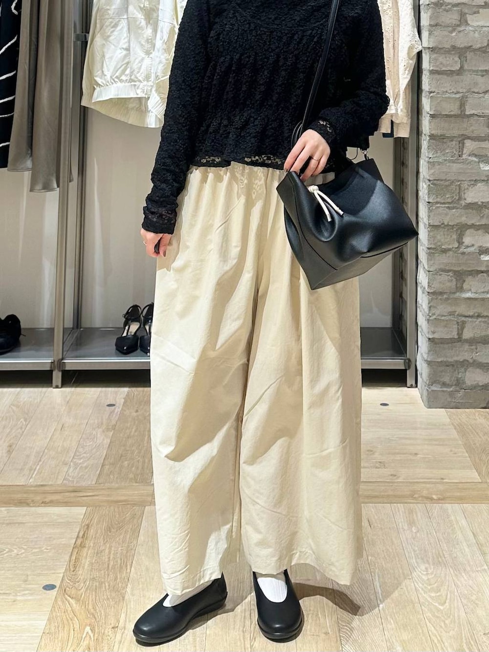 ブラック系のパンプス、ホワイト系のその他パンツ、ブラック系のトートバッグを着用したレディースの春コーディネートの4枚目の写真