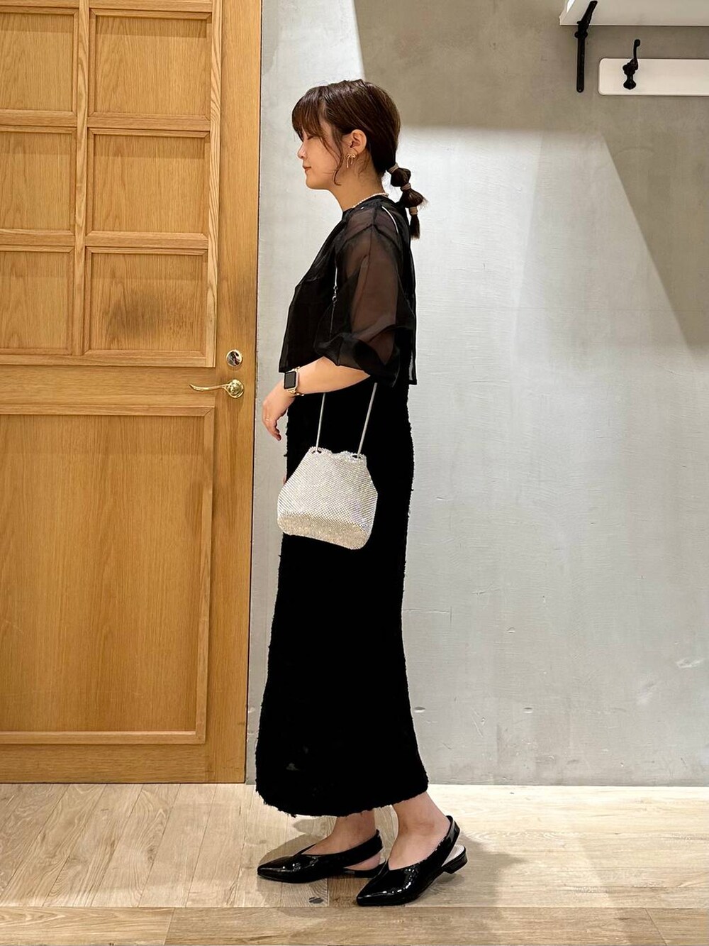 シルバー系のショルダーバッグ、ブラック系のその他シューズ、ブラック系のドレスを着用したレディースの秋コーディネートの2枚目の写真