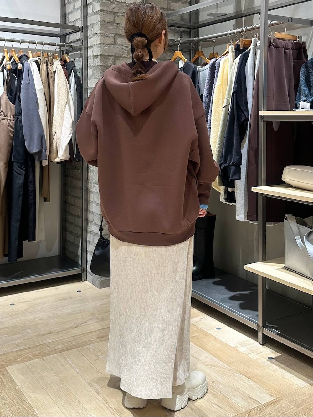 ホワイト系のブーツ、ブラウン系のニット/セーター、ホワイト系のその他アウターを着用したレディースの冬コーディネートの3枚目の写真