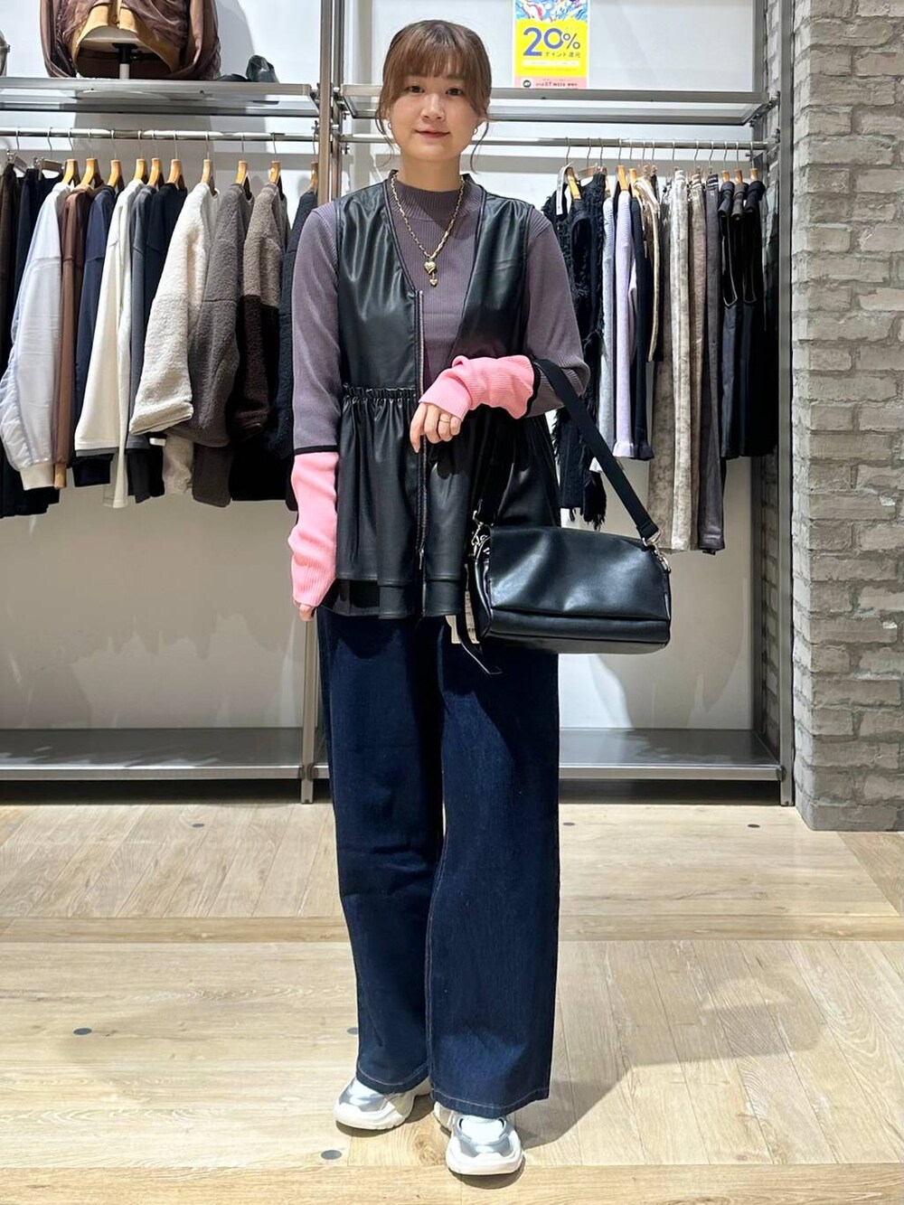 ブルー系のデニムパンツ、グレー系のニット/セーター、ホワイト系のスニーカーを着用したレディースの秋コーディネートの6枚目の写真