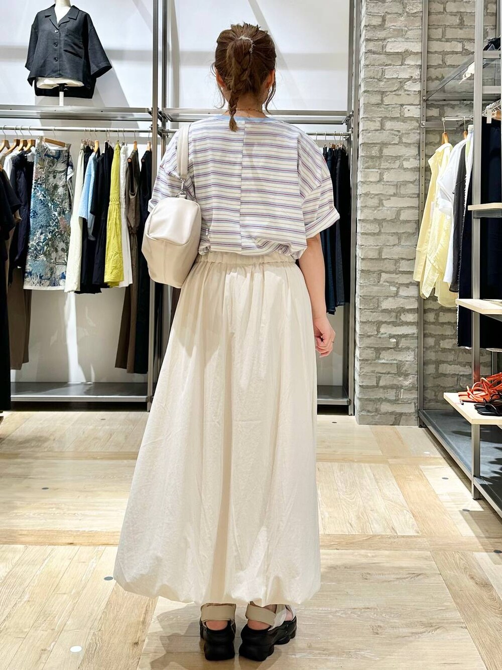 ブルー系のTシャツ/カットソー、ホワイト系のスカート、ホワイト系のショルダーバッグを着用したレディースの夏コーディネートの3枚目の写真