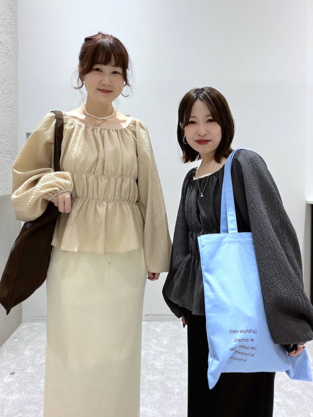 ホワイト系のスカート、ブラック系のスウェットパンツ、ブルー系のトートバッグを着用したレディースの春コーディネートの4枚目の写真