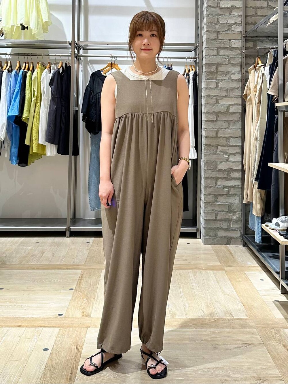 ホワイト系のタンクトップ、イエロー系のつなぎ/オールインワン、ブラック系のサンダルを着用したレディースの夏コーディネートの2枚目の写真