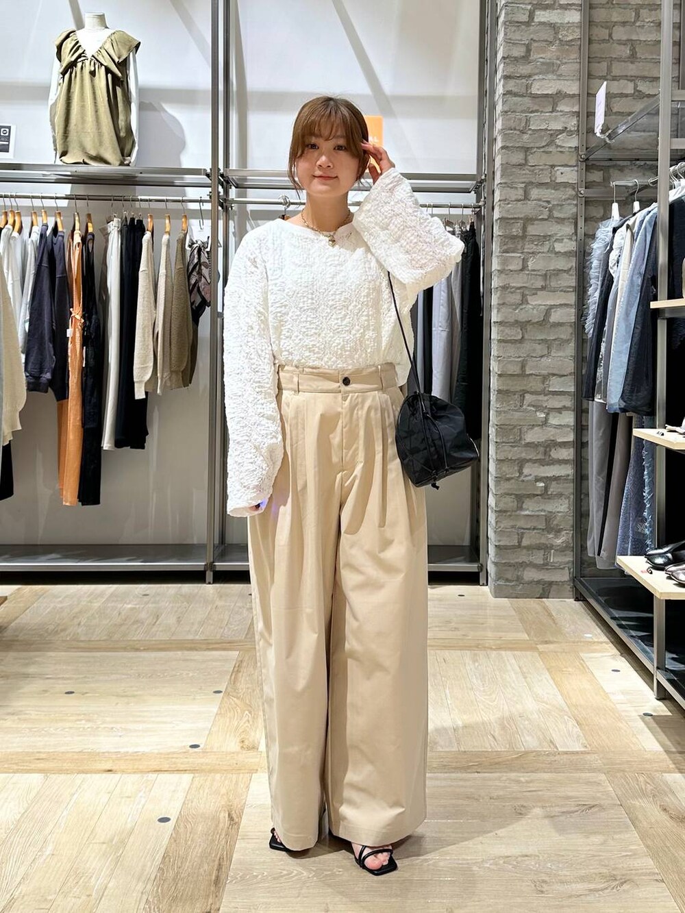 ホワイト系のショルダーバッグ、ベージュ系のその他パンツ、ホワイト系のTシャツ/カットソーを着用したレディースの春コーディネートの2枚目の写真