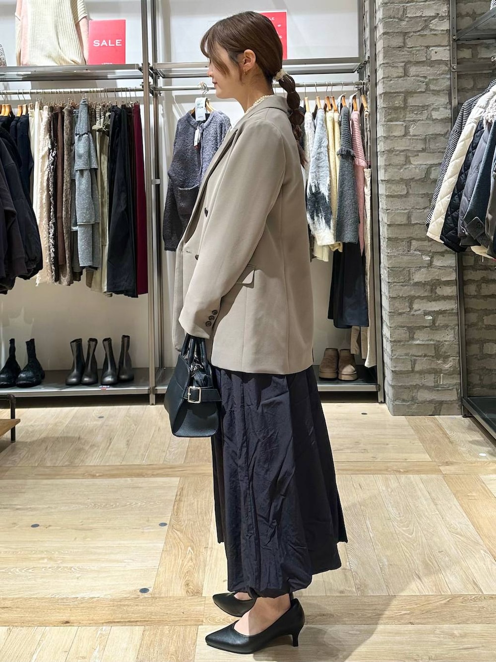 ブラウン系のテーラードジャケット、ブラック系のスカート、ホワイト系のシャツ/ブラウスを着用したレディースの冬コーディネートの2枚目の写真