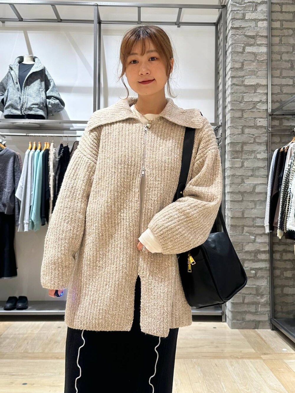 ブラウン系のブーツ、ホワイト系のTシャツ/カットソー、ブラック系のショルダーバッグを着用したレディースの秋コーディネートの5枚目の写真