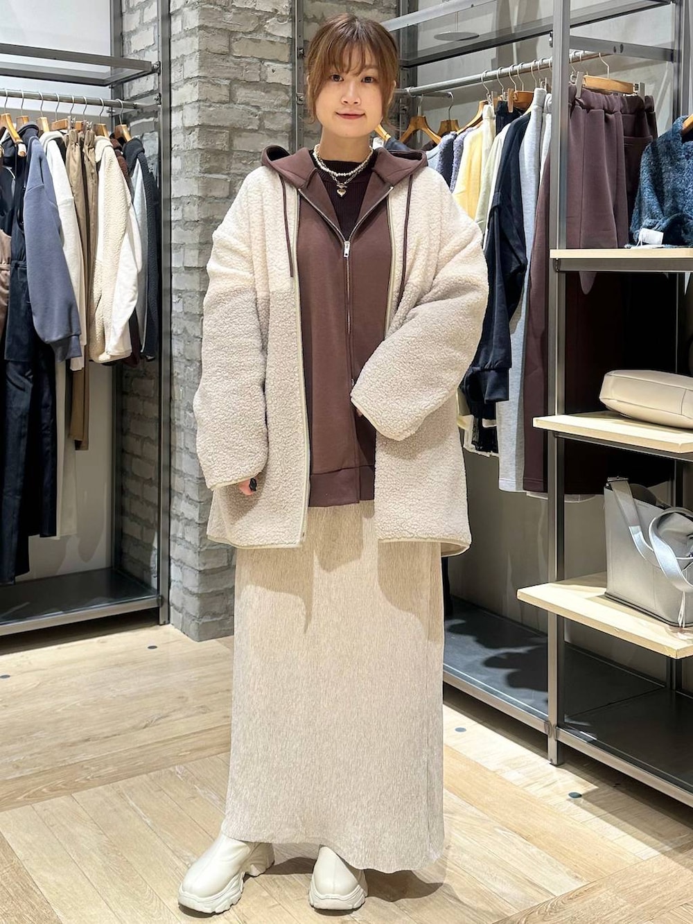 ホワイト系のブーツ、ブラウン系のニット/セーター、ホワイト系のその他アウターを着用したレディースの冬コーディネートの5枚目の写真