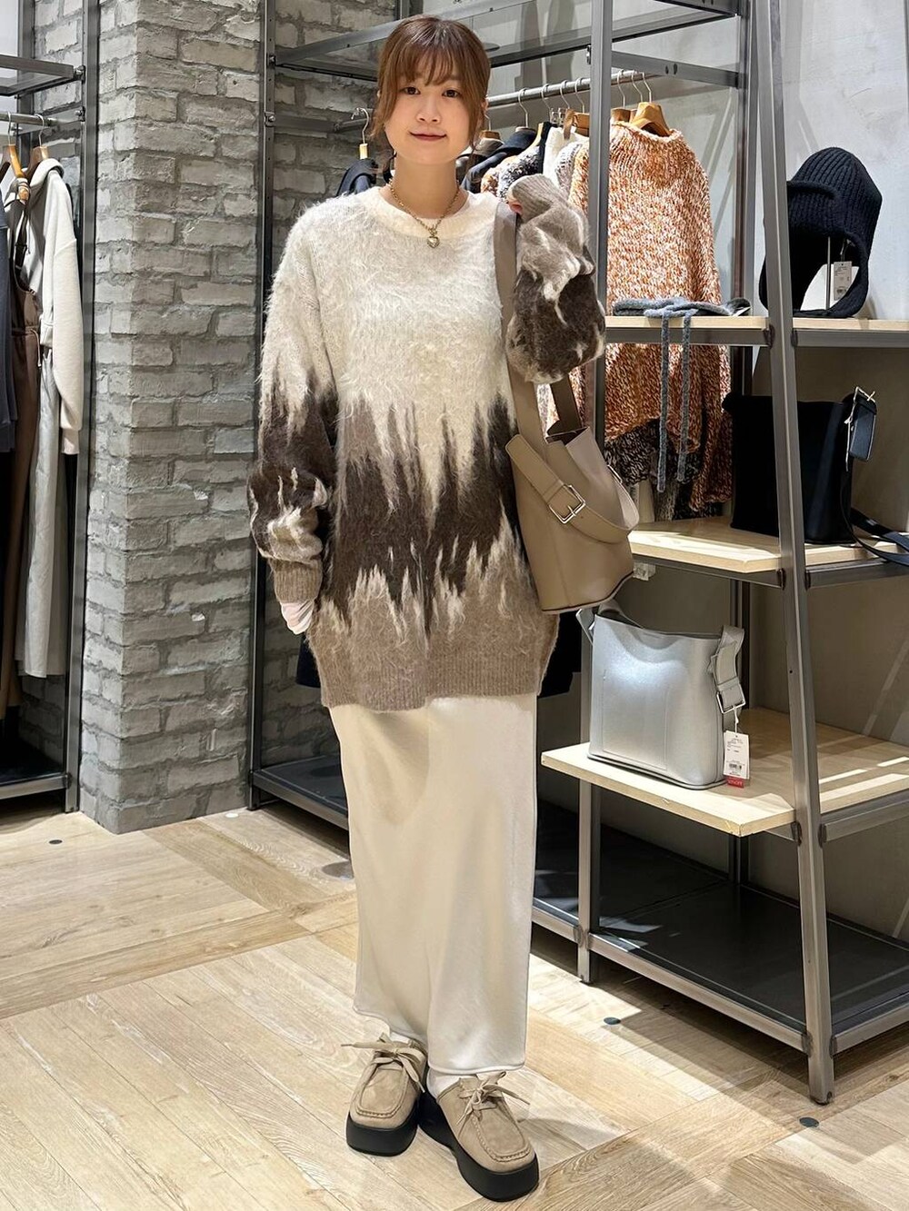 ホワイト系のスカート、ブラウン系のショルダーバッグ、ベージュ系のその他シューズを着用したレディースの冬コーディネートの4枚目の写真