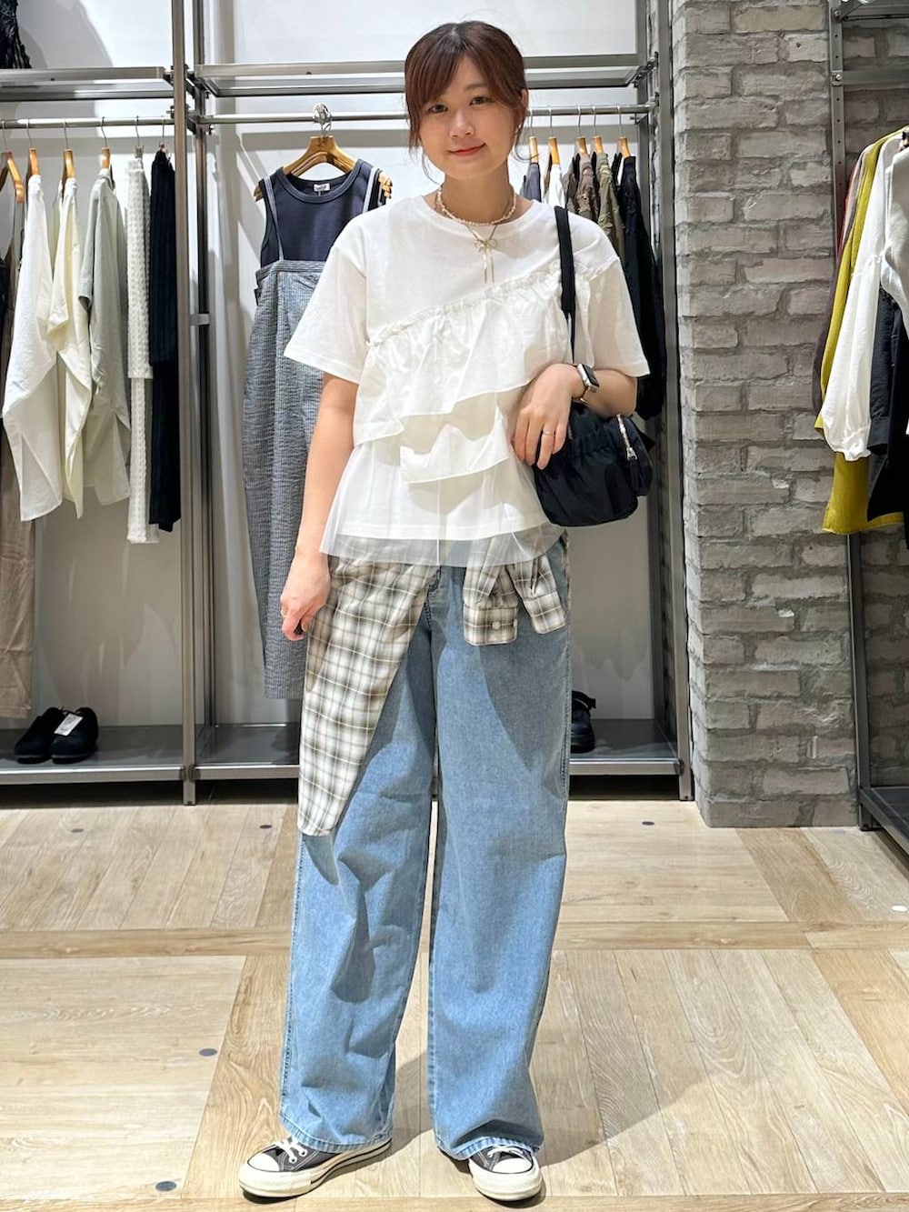 イエロー系のスニーカー、ブルー系のデニムパンツ、グレー系のボストンバッグを着用したレディースの春コーディネートの2枚目の写真