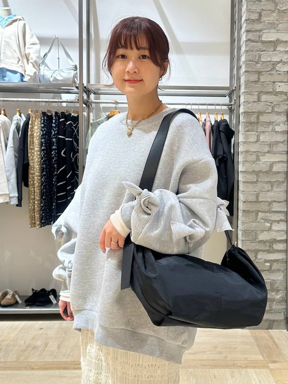 グレー系のスウェット、ブラック系のその他シューズ、ブラック系のショルダーバッグを着用したレディースの春コーディネートの6枚目の写真