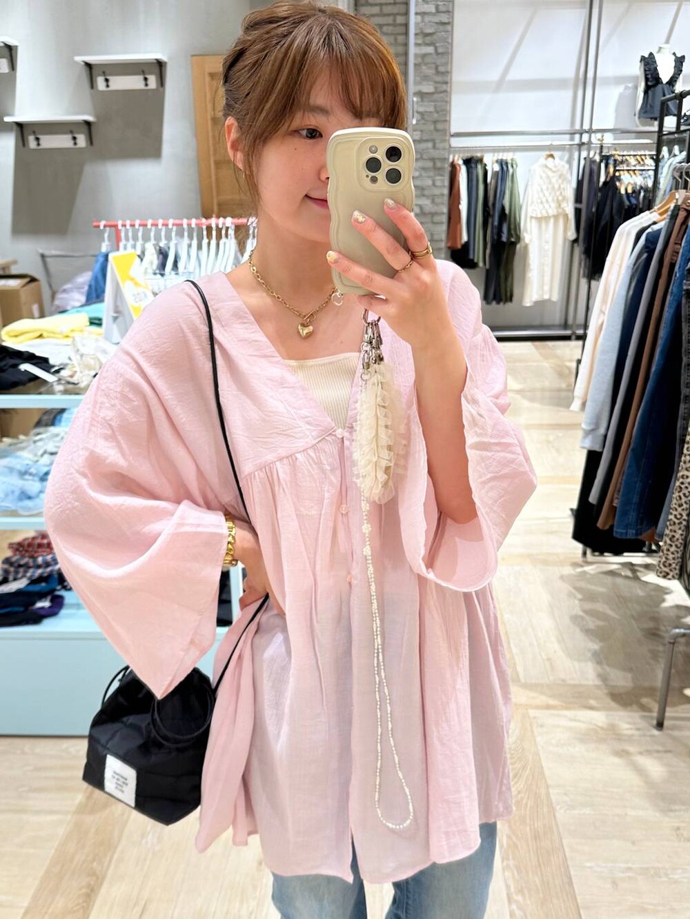 ブラック系のスニーカー、ホワイト系のタンクトップ、ブルー系のデニムパンツを着用したレディースの春コーディネートの2枚目の写真