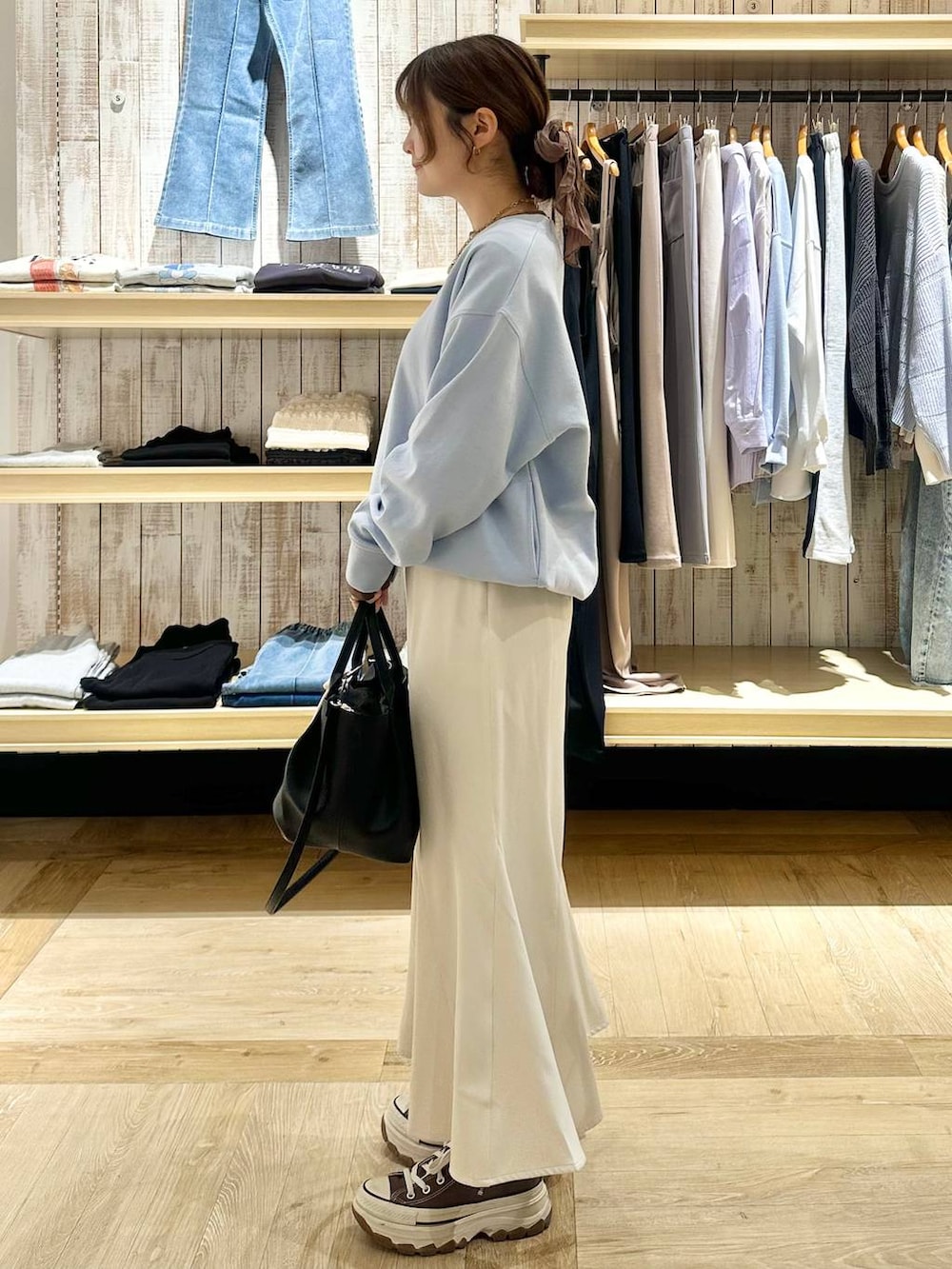 ホワイト系のスカート、ブラック系のトートバッグ、ブルー系のTシャツ/カットソーを着用したレディースの冬コーディネートの2枚目の写真