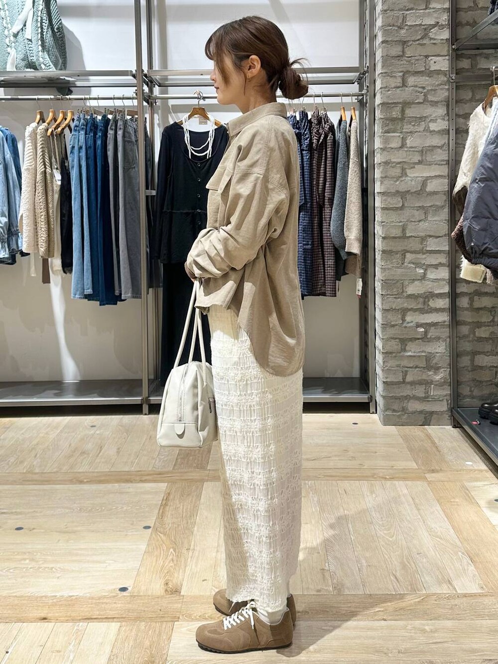 ホワイト系のスカート、ベージュ系のシャツ/ブラウス、ホワイト系のボストンバッグを着用したレディースの冬コーディネートの2枚目の写真