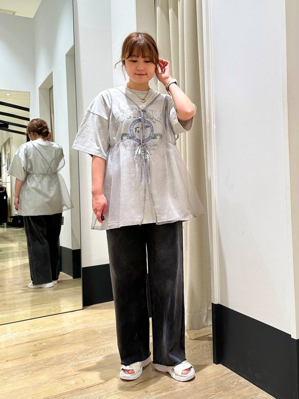 ホワイト系のサンダル、グレー系のベスト、ブラック系のデニムパンツを着用したレディースの春コーディネートの2枚目の写真