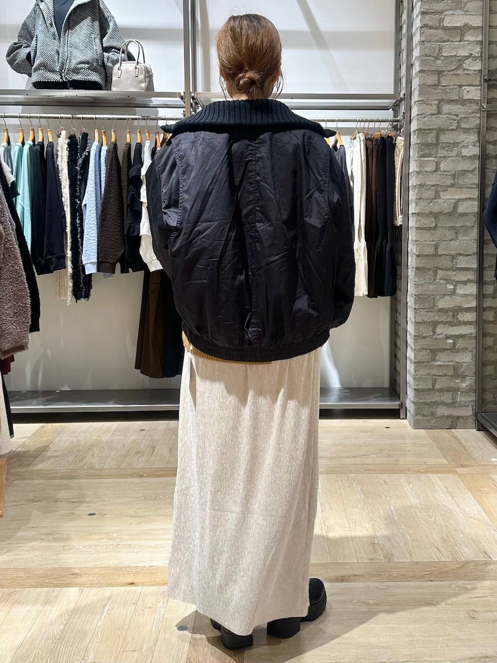 イエロー系のニット/セーター、ブラック系のボストンバッグ、ブラック系のブーツを着用したレディースの秋コーディネートの3枚目の写真