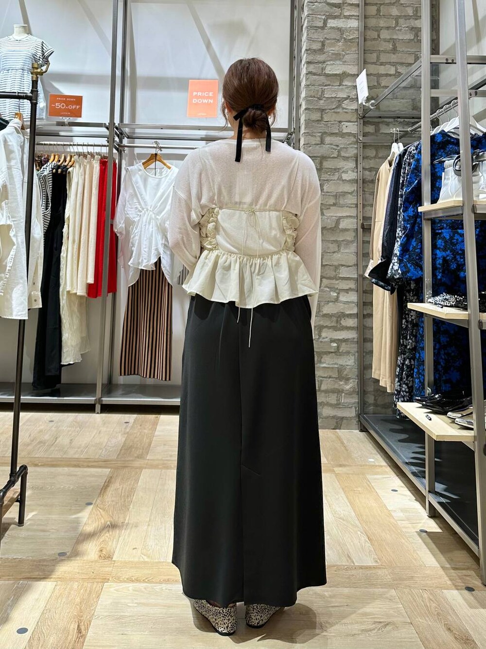 ホワイト系のTシャツ/カットソー、ブラック系のボストンバッグ、ホワイト系のパンプスを着用したレディースの夏コーディネートの4枚目の写真