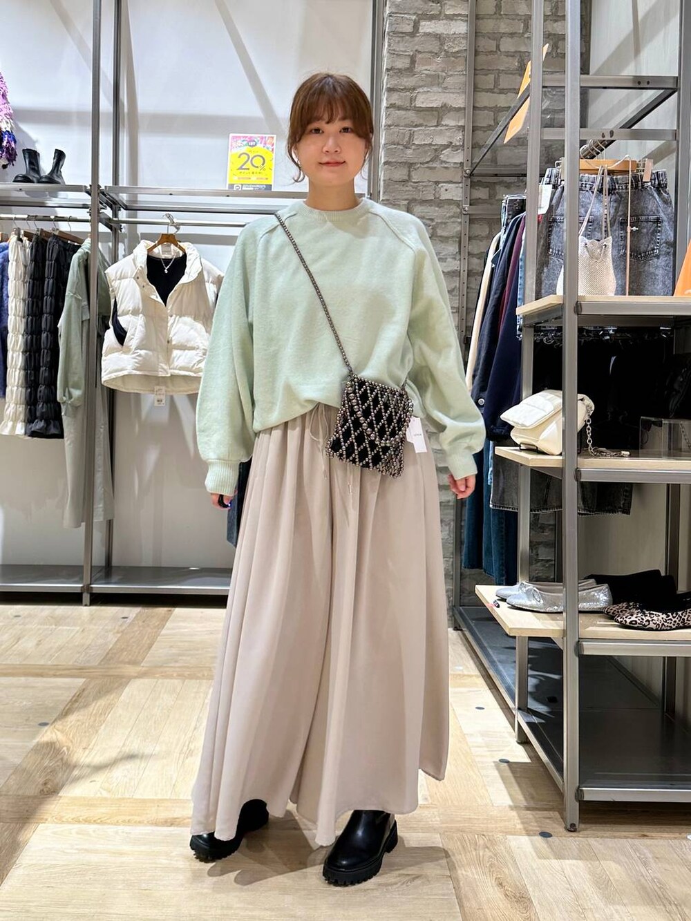 グリーン系のニット/セーター、ブラック系のブーツ、ベージュ系のその他パンツを着用したレディースの秋コーディネートの2枚目の写真