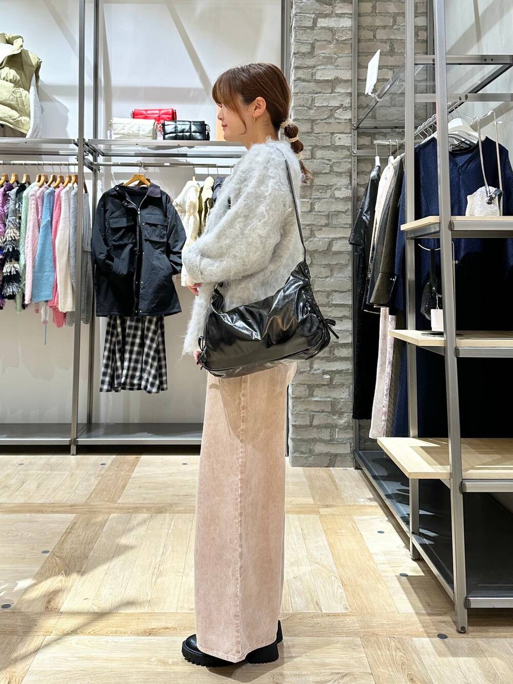 ブラック系のブーツ、ホワイト系のニット/セーター、グレー系のカーディガン/ボレロを着用したレディースの冬コーディネートの2枚目の写真