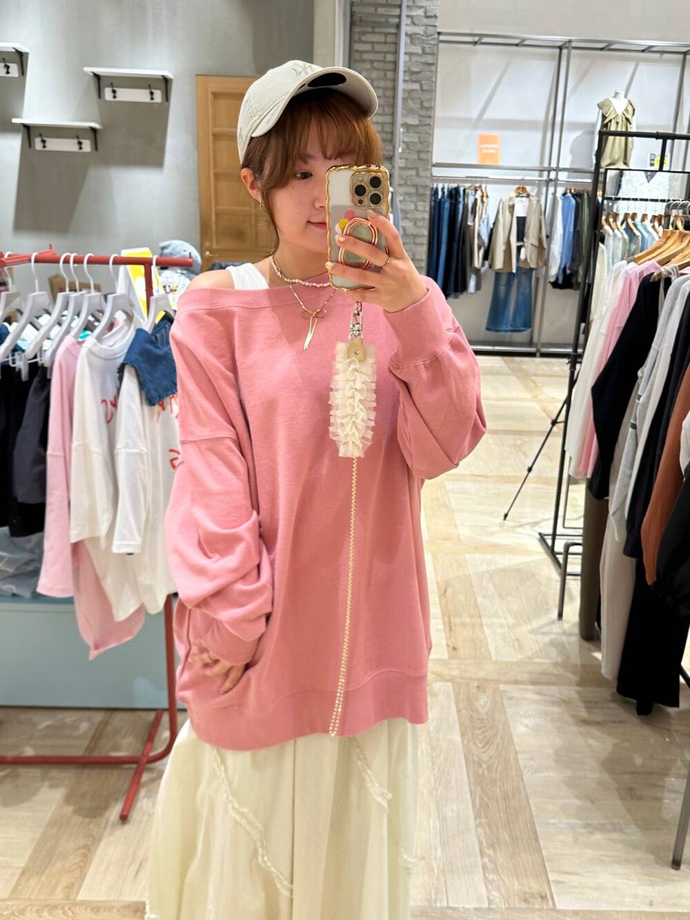 ブラック系のショルダーバッグ、ピンク系のTシャツ/カットソー、ベージュ系のスニーカーを着用したレディースの春コーディネートの5枚目の写真