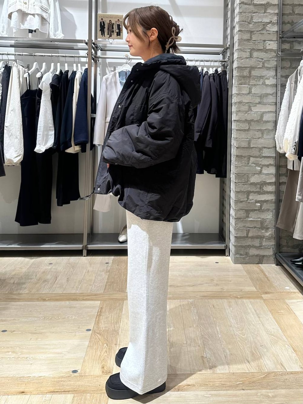 ブラック系のその他アウター、ホワイト系のTシャツ/カットソー、グレー系のショルダーバッグを着用したレディースの冬コーディネートの2枚目の写真